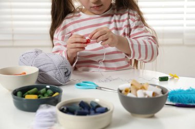 Küçük kız Beyaz Masa 'da el işi yapıyor, yakın plan. Çocuk yaratıcılığı ve el yapımı el işi
