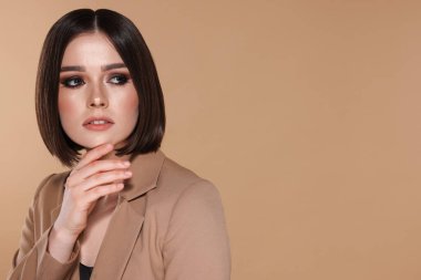 Bej arka planda harika düz saçları olan güzel bir genç kadının portresi.