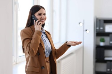 Ofiste akıllı telefondan konuşan bankacı, mesaj için alan