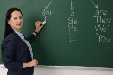 Sınıfta tahtaya yakın ders sırasında İngilizce öğretmeni