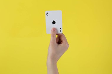 Sarı arka planda kart oynayan kadın, yakın plan