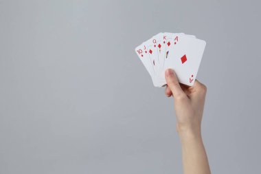 Gri arka planda iskambil oynayan kadın, yakın plan. Metin için boşluk