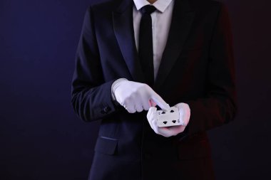 Karanlık arka planda oyun kartları olan bir illüzyonist, yakın plan. Metin için boşluk