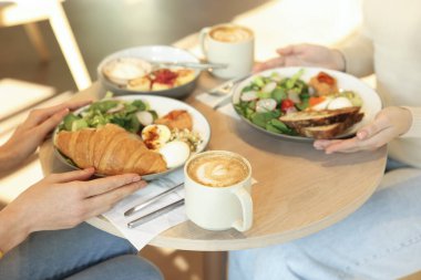 Kafede lezzetli bir kahvaltı yapan kadınlar, yakın plan.