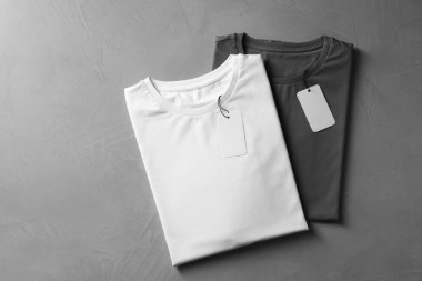 Gri arka planda farklı boş tişörtler, üst manzara. Tasarım için model