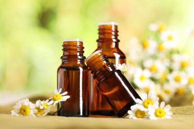 Kumaş üzerinde gerekli yağ ve papatya çiçekleri, yakın plan.