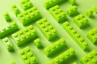 İnşaat oyuncağı. Açık yeşil arkaplan üzerinde birçok yapı taşı, görünümün üzerinde