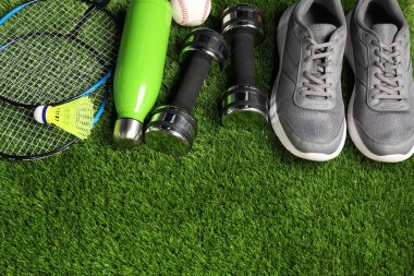 Suni çimlerin üzerinde farklı spor aletleri var. Metin için boşluk