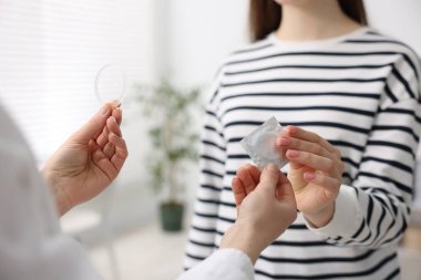 Jinekolog klinikte kadınlara farklı doğum kontrol ürünleri gösteriyor.
