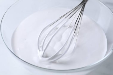 Beyaz masada çırpılmış krema, yakın plan.