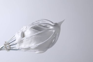 Beyaz arka planda krem şantili çırpma çırpma, yakın plan. Metin için boşluk