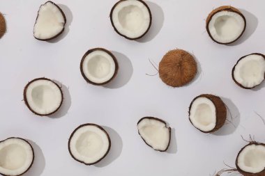 Kırık hindistan cevizi parçaları hafif arka planda, düz yerde.