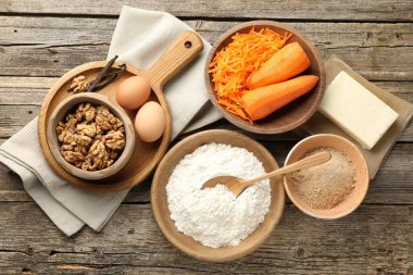 Tahta masada havuçlu kek yapmak için farklı malzemeler.