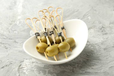 Gri dokulu masada salamura edilmiş zeytinler, yakın plan.