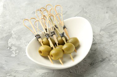 Gri dokulu masada salamura edilmiş zeytinler, yakın plan.