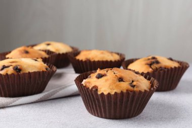 Açık gri masada çikolata parçalı lezzetli kek, yakın plan.