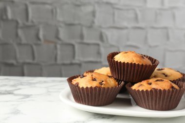 Beyaz mermer masanın üzerinde çikolata parçalı lezzetli kek, yakın plan. Metin için boşluk