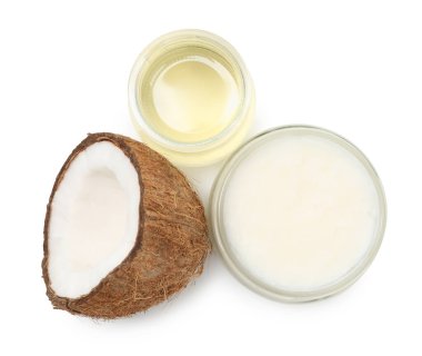 Cam kavanozlarda yağlar pişiyor ve hindistan cevizi yarısı beyaz, üstten görünüyor.