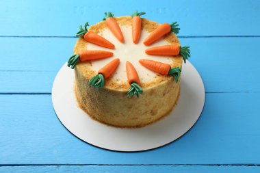 Açık mavi ahşap masada nefis ev yapımı havuçlu kek.