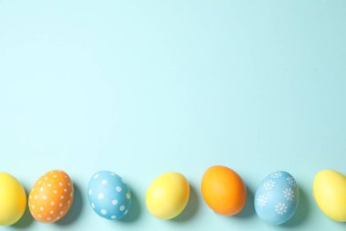 Açık mavi arka planda güzel dekore edilmiş Paskalya yumurtaları, düz. Metin için boşluk