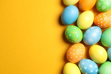 Turuncu arka planda güzel dekore edilmiş Paskalya yumurtaları. Metin için boşluk