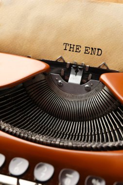 Üzerinde kağıt olan daktilo, yakın plan. Yazılan metin: Bitiş