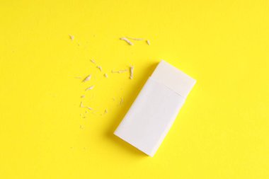 Sarı arka planda bir silgi ve kırıntılar, üst görünüm