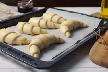 Beyaz ahşap masada çiğ kruvasanlar, yakın plan.