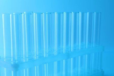 Açık mavi arka planda boş test tüpleri, yakın plan. Laboratuvar camları.