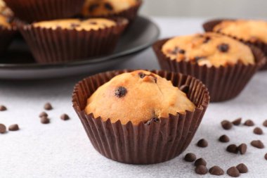 Açık gri masada çikolata parçalı lezzetli kek, yakın plan.