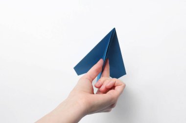 Beyaz arka planda el yapımı kağıt uçaklı kadın, yakın plan.