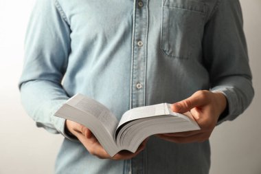 İngilizce İncil okuyan adam arka planda, yakın planda.