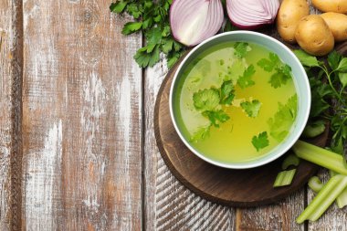 Lezzetli tavuk buğlonu kasede ve ahşap masada malzemeler düz yerde. Metin için boşluk