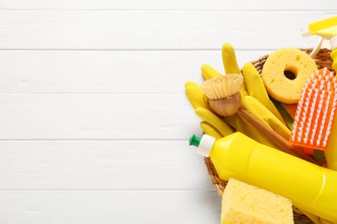 Beyaz ahşap masadaki temizlik malzemeleri ve aletler, üst manzara. Metin için boşluk