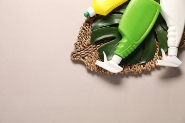 Bej arka planda farklı temizlik ürünleri şişeleri, üst manzara. Metin için boşluk