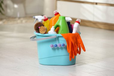 Banyoda yerde farklı temizlik malzemeleriyle dolu bir kova.