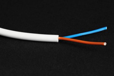 Siyah arkaplanda beyaz şeritli elektrik kablosu, yakın plan.