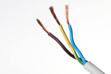 Beyaz arka planda bakır telleri olan soyulmuş elektrik kablosu