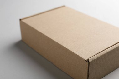 Beyaz arka planda boş bir karton kutu, yakın plan. Tasarım için model