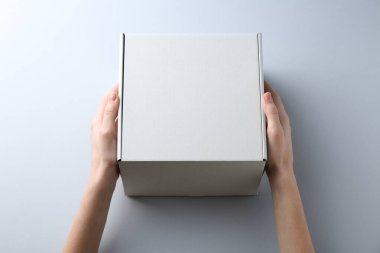 Beyaz arka planda boş karton kutusu olan kadın, yakın plan. Tasarım için model