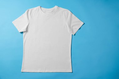 Açık mavi arka planda boş bir tişört, üst manzara. Tasarım için model