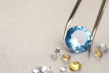 Güzel değerli taşları olan cımbızlar ışık desenli masa, yakın plan. Metin için boşluk