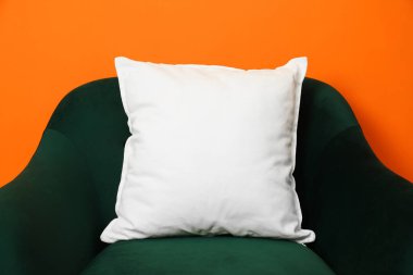 Boş yumuşak yastık turuncu arka planda rahat koltukta