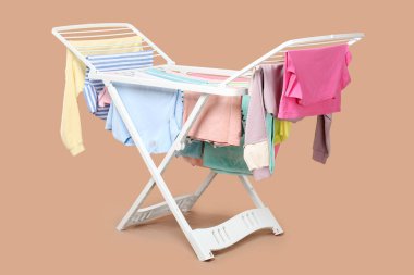 Bej arka planda temiz çamaşırlı kuru askı.