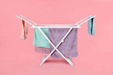 Açık pembe arka planda temiz çamaşırlı kuru askı.