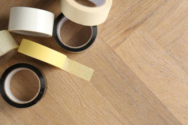 Tahta masanın üzerinde farklı yapışkan bant ruloları var. Metin için boşluk