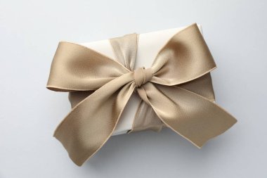 Işık arkaplan üzerinde güzel bir fiyonk olan hediye kutusu, üst manzara