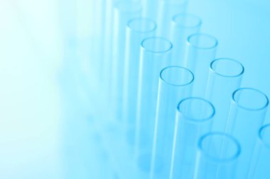 Açık mavi arka planda boş test tüpleri, yakın plan. Laboratuvar camları.