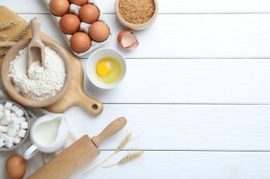 Hamur için merdane ve malzemeler beyaz ahşap masada, düz yerde. Metin için boşluk