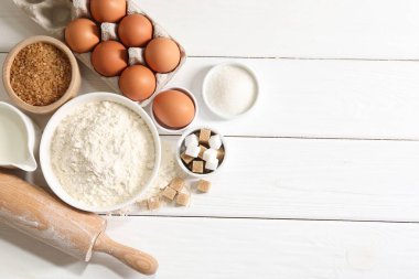 Hamur için merdane ve malzemeler beyaz ahşap masada, düz yerde. Metin için boşluk